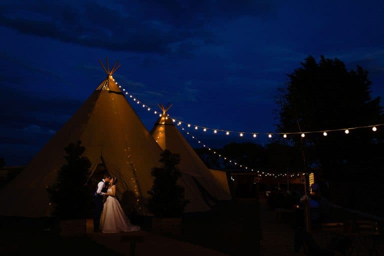 A couple kiss at their Scarborough tipi wedding. Fun and creative wedding photography by Emma + Rich