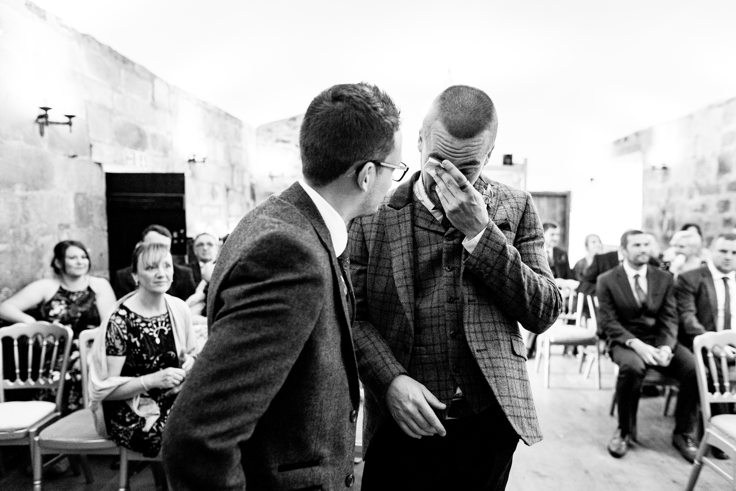 groom wipes tears whilst waiting for bride. esk valley wedding photography by emma and rich.