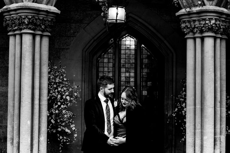 bride and groom standing outside of the manor by the lake - fun wedding photography by emma + rich