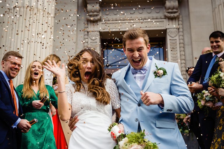 bride and groom running through confetti on the steps of the old marylebone town hall