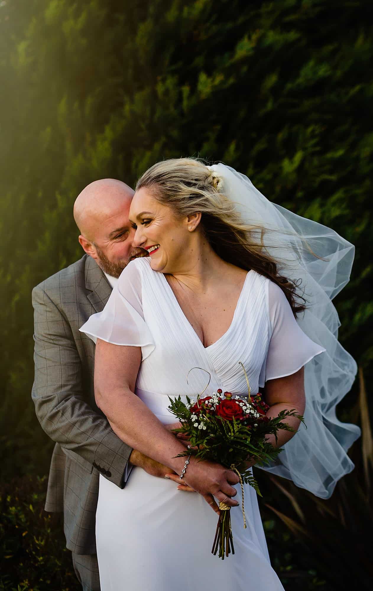 a newly married couple in the grounds of ox pasture hall. fun wedding photography by emma and rich