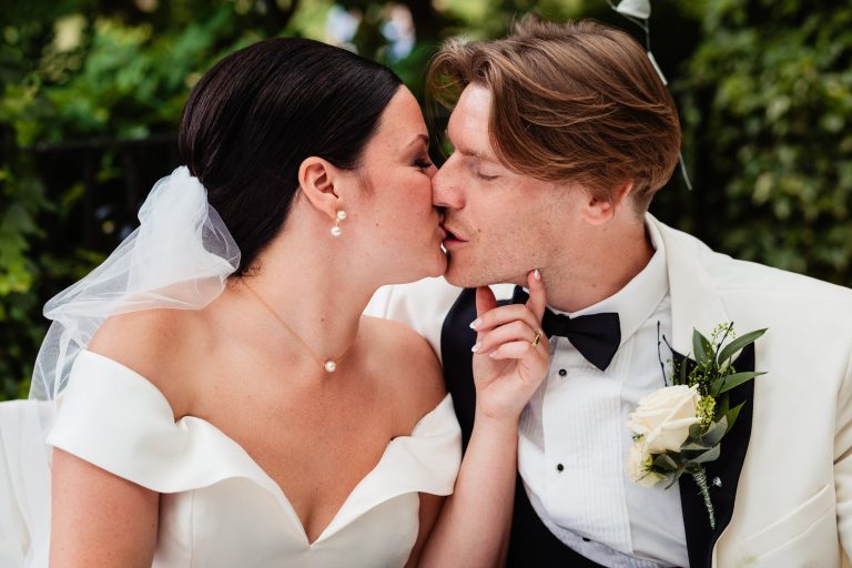 a bride and groom kiss as they sign the wedding register. sun pavilion Harrogate wedding photography by emma and rich.